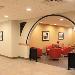 A stylish lobby featuring red seating and elegant wall art, designed for comfort and relaxation.