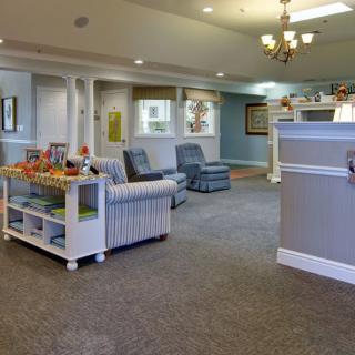 A welcoming and brightly lit waiting room with comfortable seating and children's toys.