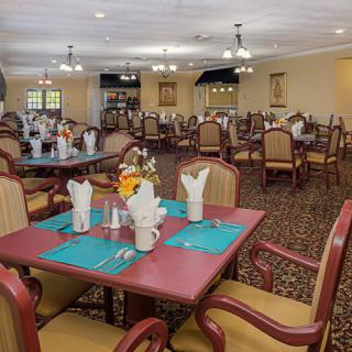 An elegant dining room with neatly set tables and comfortable chairs.
