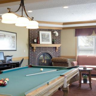 A cozy recreation room featuring a pool table and a fireplace.