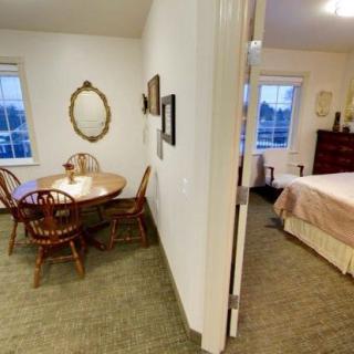 A view of a cozy dining area adjacent to a bedroom with classic wooden furniture.