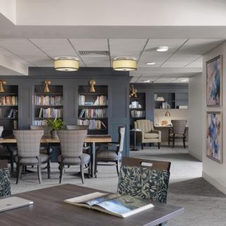 A modern library interior with comfortable seating and shelves filled with books.