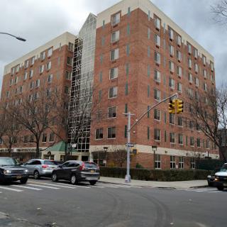A contemporary brick building located at a busy intersection, showcasing modern architecture.