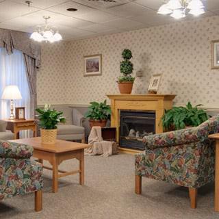 A cozy living room with comfortable seating, a fireplace, and decorative plants.