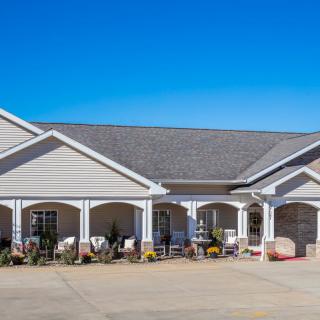 A single-story residential building with a large porch and gabled roof.