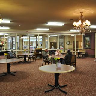 A spacious lobby area featuring tables and chairs, designed for social interactions and relaxation.