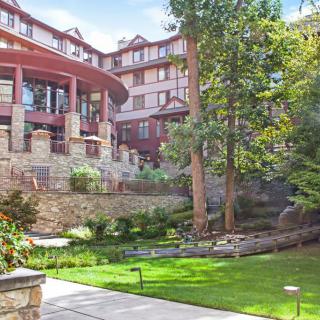 A scenic view of a building with an elegant garden and lush greenery.