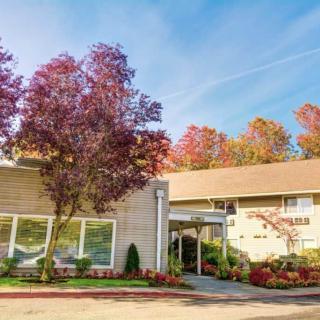 A well-maintained building surrounded by colorful autumn trees under a clear blue sky.