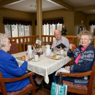 Seniors enjoying breakfast together in a cozy dining area.