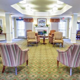 A cozy lounge area with armchairs arranged around a fireplace.