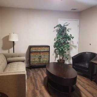 Cozy living room with a sofa, armchair, and coffee table.