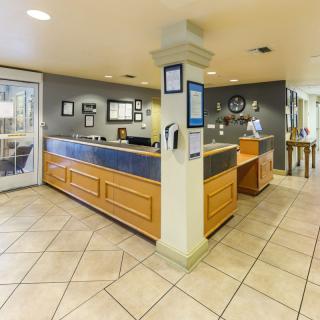 A spacious reception area with a wooden desk and tiled flooring.