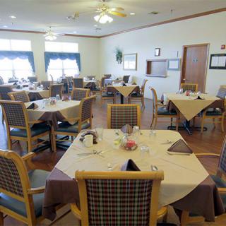 A neatly arranged dining room with tables and chairs set for a meal.
