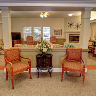 A cozy interior seating area with two chairs and a small table displaying a floral arrangement.