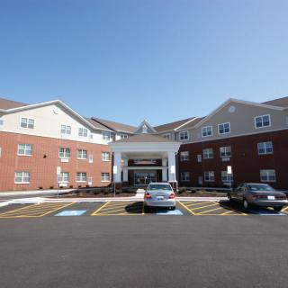 A residential building with a parking lot and entrance.