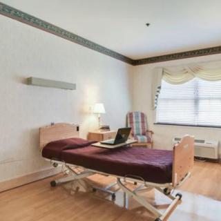 A hospital room with a bed and a laptop on it.