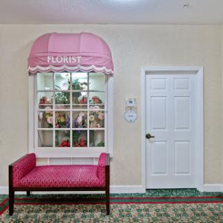 A cozy and inviting interior space featuring a stylish pink bench and a decorative window with a canopy.