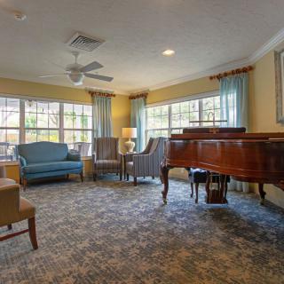 A cozy living room with a grand piano and comfortable seating.