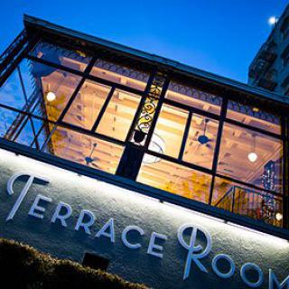 The Terrace Room building glows with warm lighting during the evening.