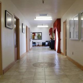 A well-lit office hallway with tiled flooring and decorated walls.