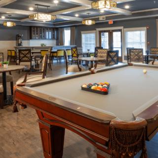 A spacious game room featuring a billiards table and a dining area.