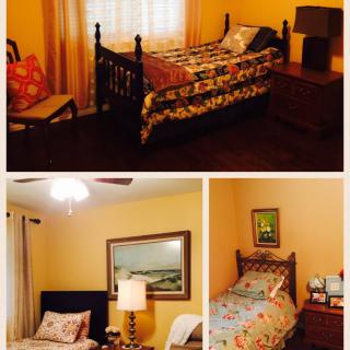 A cozy bedroom with a vintage bed frame, colorful bedding, and warm lighting.