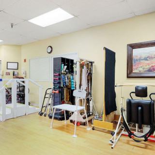 A well-equipped rehabilitation room with various exercise machines and therapy tools.