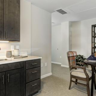 A cozy kitchen and dining area with dark cabinets and a wooden dining table.