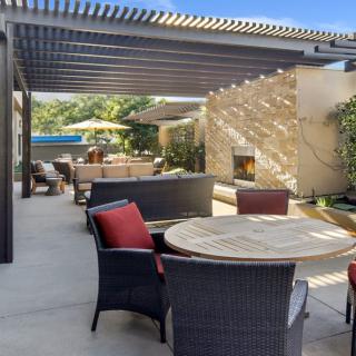 A sunny outdoor patio with comfortable seating and a pergola.