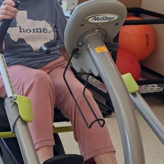 A person is using exercise equipment, possibly for rehabilitation or therapy, indoors.