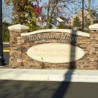 An entrance sign for the Woodhaven Lakes community, featuring a stone design.