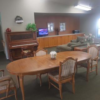 A cozy living room with a piano, dining table, and comfortable seating area.