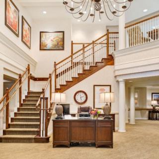 Luxurious interior with a grand staircase and reception desk.