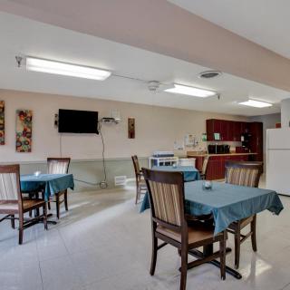 A cozy dining area with tables and chairs adjacent to a kitchen.