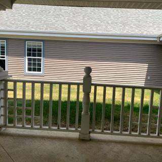 A view of the backyard from a porch, showcasing the house next door and greenery.