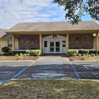 A welcoming single-story building with a well-maintained entrance and parking area.