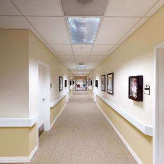 A long, well-lit hallway with artwork on the walls in a building.