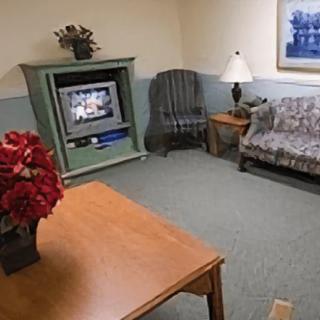 A cozy living room with a TV, sofa, and table.