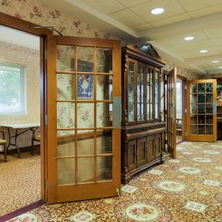 A traditional hallway with wooden doors and a carpeted floor.
