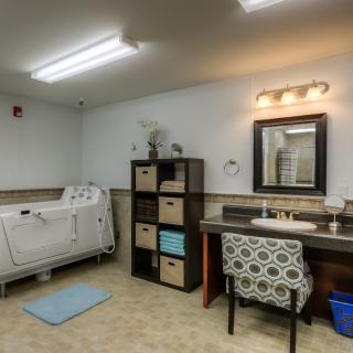 Spacious bathroom with a modern bathtub, vanity area, and organized shelving.
