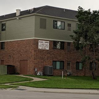 A residential brick apartment building with green siding.