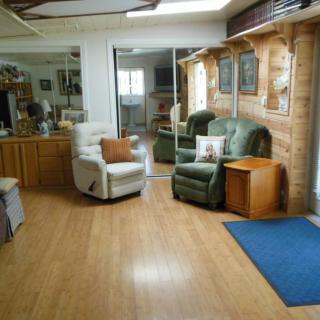 A cozy living room with armchairs and a wooden floor, featuring home decor elements.