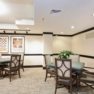 A cozy dining area with tables, chairs, and wall artwork.