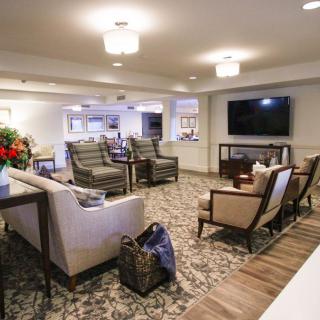 A modern and spacious living room with comfortable seating and a large television.