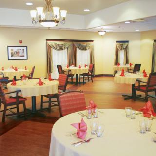 An elegant dining room setup with tables adorned with tablecloths and folded napkins.