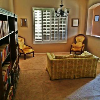 A cozy living room with vintage furniture and a well-stocked bookshelf.