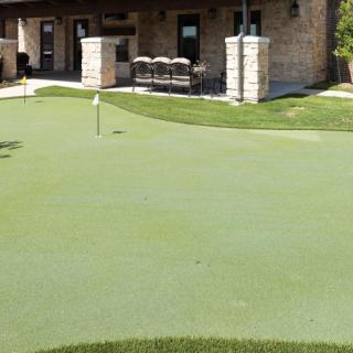 A well-maintained putting green in front of a building.