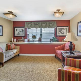 Cozy living room with a sofa, armchairs, and decorative elements under soft lighting.