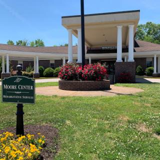 A view of a healthcare facility with vibrant landscaping and clear signage.