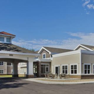 A modern building with a covered entrance and clear skies above.